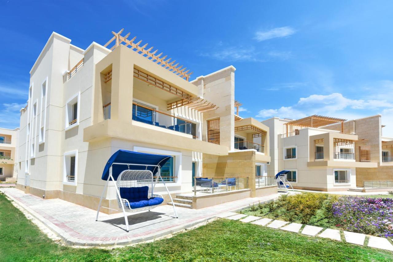 Tolip Resort El Galala Majestic Айн Сохна Екстериор снимка The photo displays a modern residential complex featuring two or more white buildings with a contemporary architectural design. Each building has balconies, large windows, and a sunshine-friendly layout that maximizes natural light. In the foreground